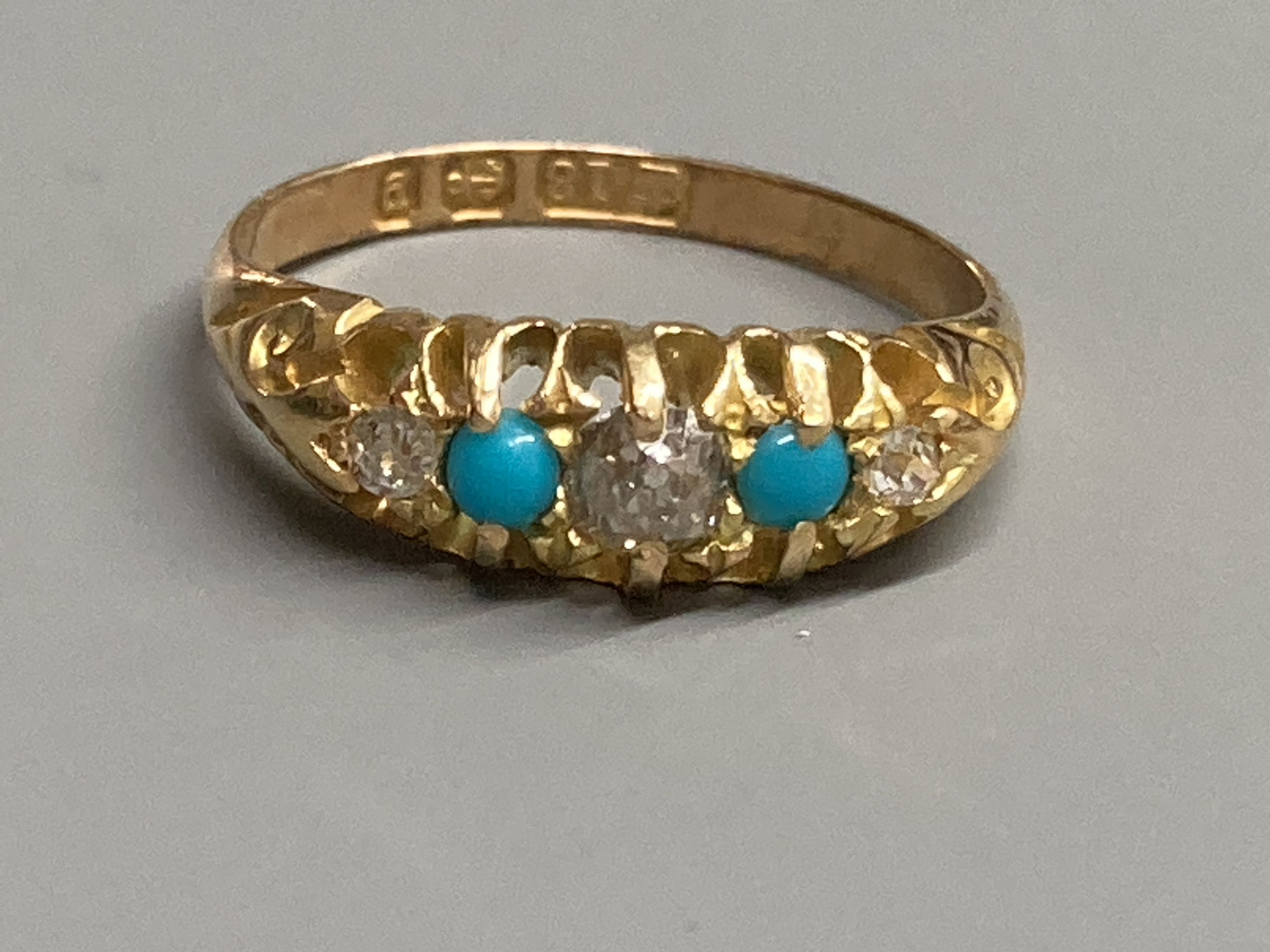 A late Victorian 18ct gold, three stone diamond and two stone turquoise set half hoop ring, size L, gross 3.4 grams.